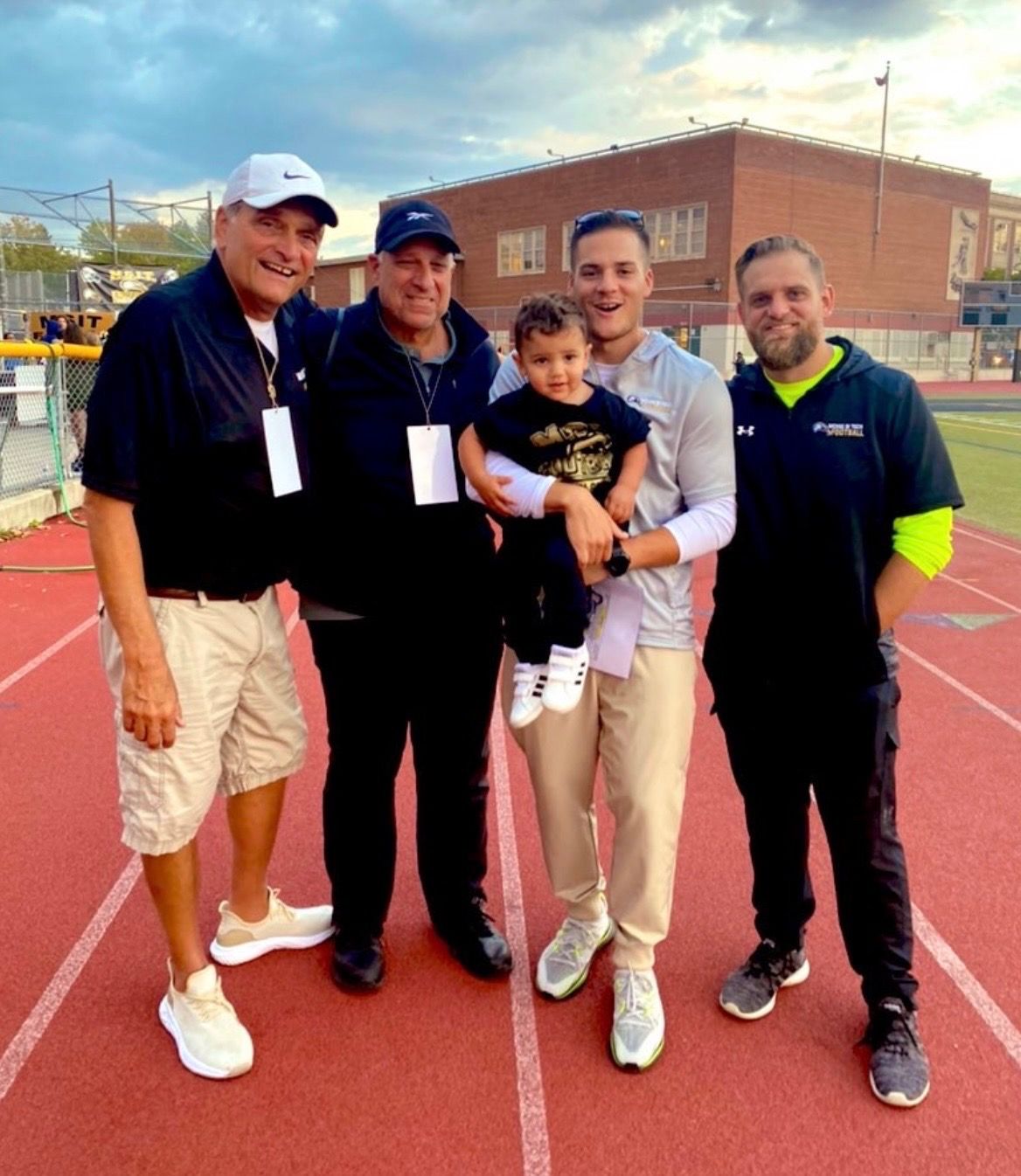 App with three men and a baby at the track