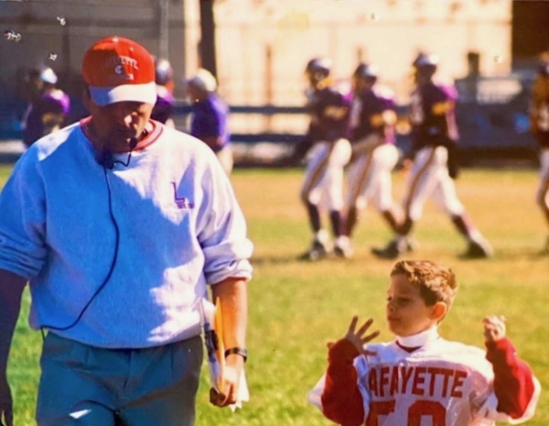 A young Chris App on the sideline with his father