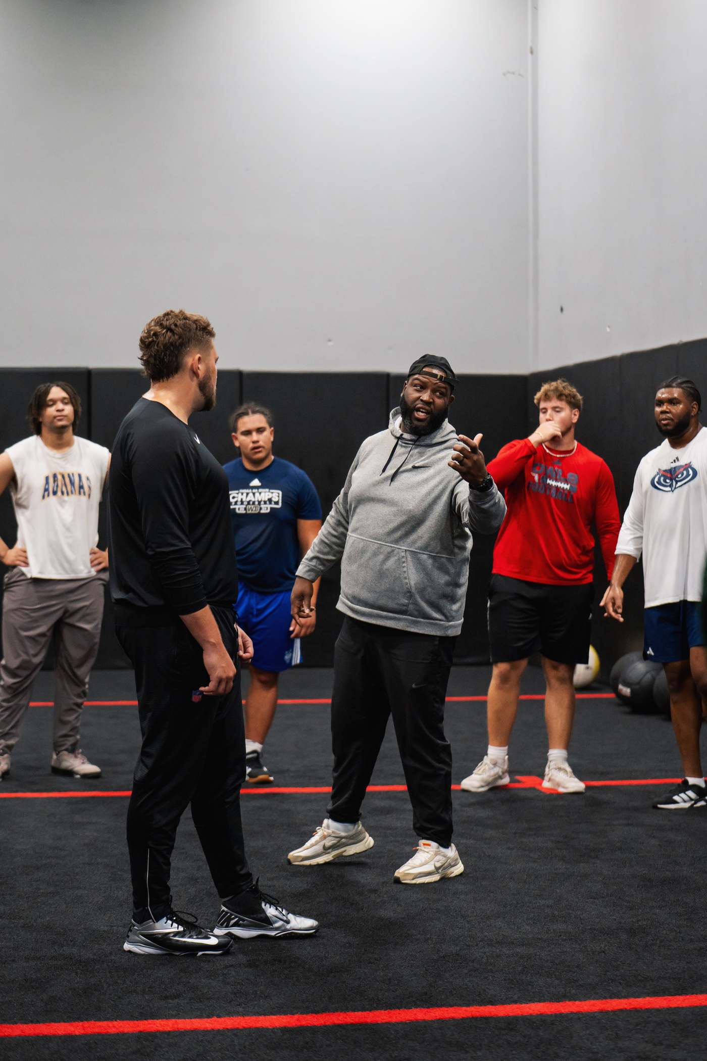 Wilson coaching a group of linemen on the turf at Crafting Linemen